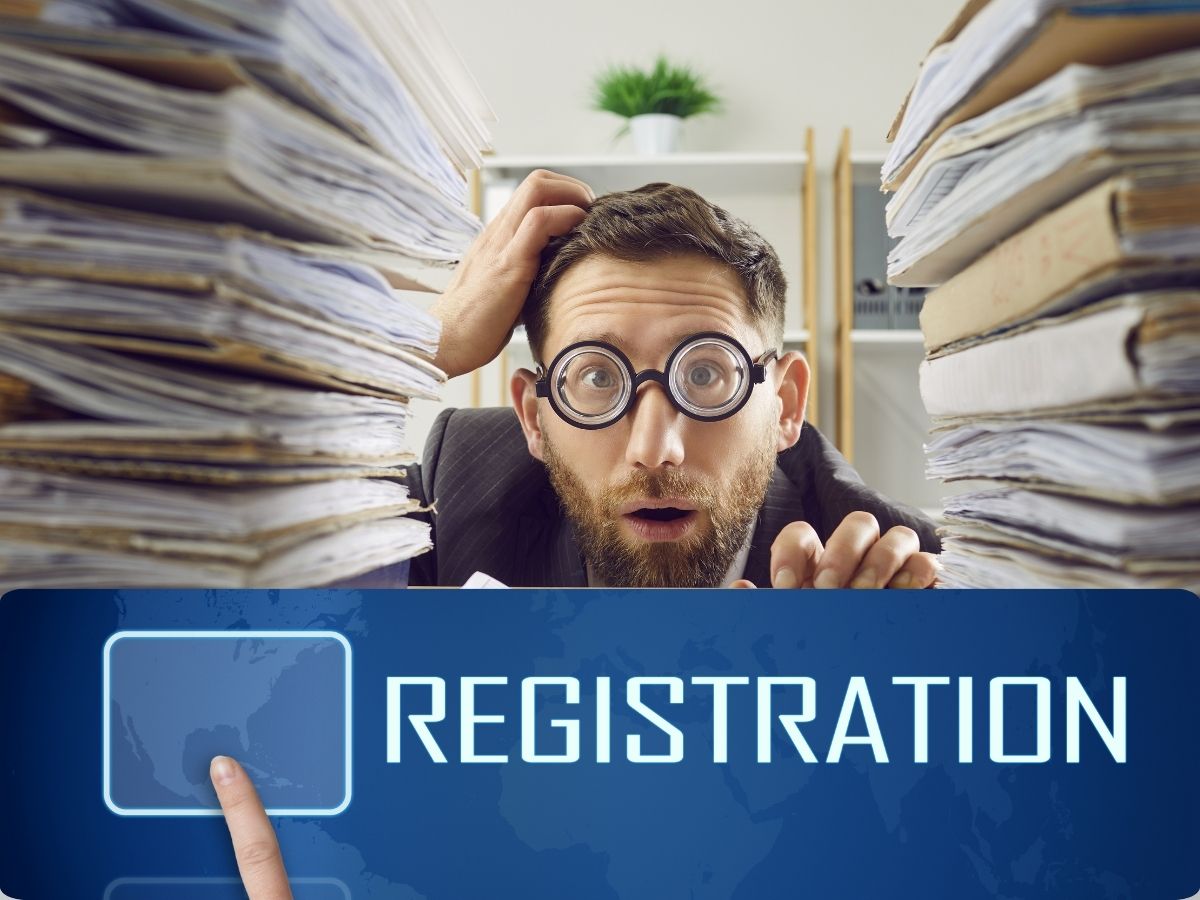 Man with desk buried under papers scratching his head.